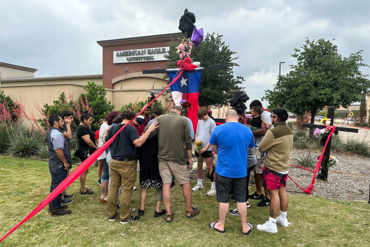 People pray at a memorial for the victims of the mass shooting at a mall in Allen, Texas, on May 7, 2023.