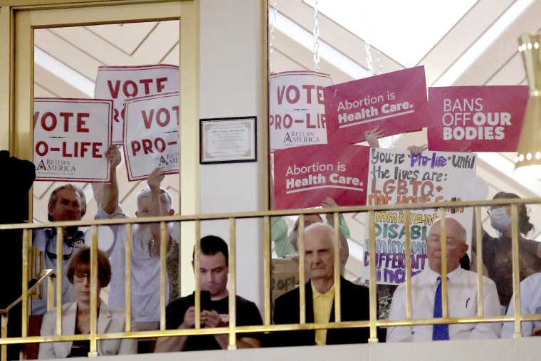 Protesters on both sides of the issue hold signs as North Carolina House members debate, Tuesday, May 16, 2023, in Raleigh, N.C., on whether to override Democratic Gov. Roy Cooper's veto of a bill that would change the state's ban on nearly all abortions from those after 20 weeks of pregnancy to those after 12 weeks of pregnancy. Both the Senate and House had to complete successful override votes for the measure to be enacted into law. The Senate voted to override the veto earlier and the House also voted to override. (AP Photo/Chris Seward)