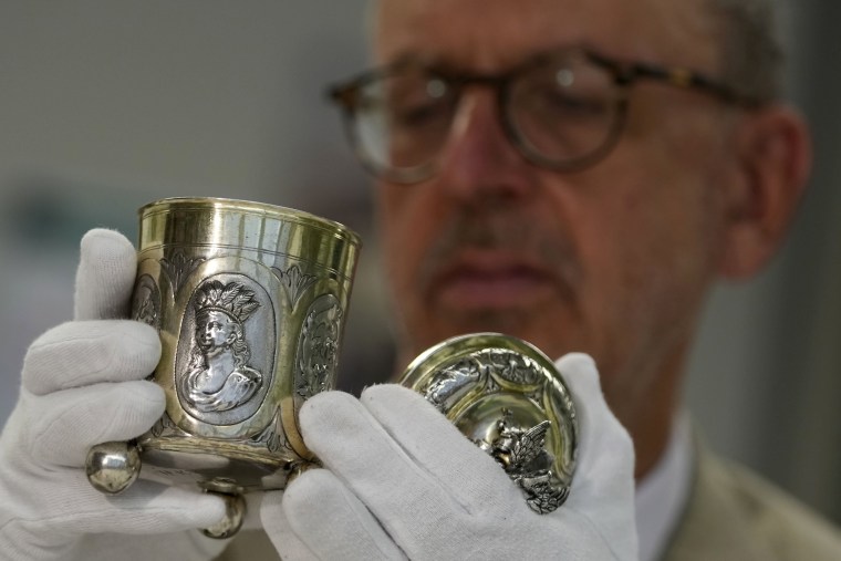 Matthias Weniger lifts one of the 111 silver objects stolen by the Nazis from the Jews, in Munich, Germany
