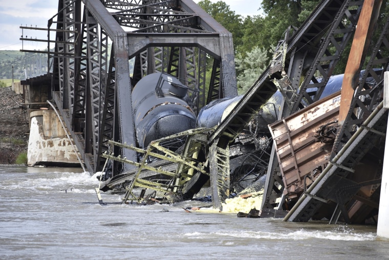 Several train cars are immersed in the Yellowstone River after a bridge collapse near Columbus, Mont., on Saturday, June 24, 2023. (AP Photo/Matthew Brown)