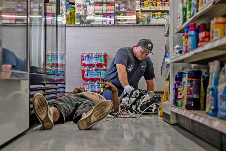 A person receives medical attention after collapsing in a convenience store on July 13, 2023 in Phoenix. EMT was called after the person said they experienced hot flashes, dizziness, fatigue and chest pain.