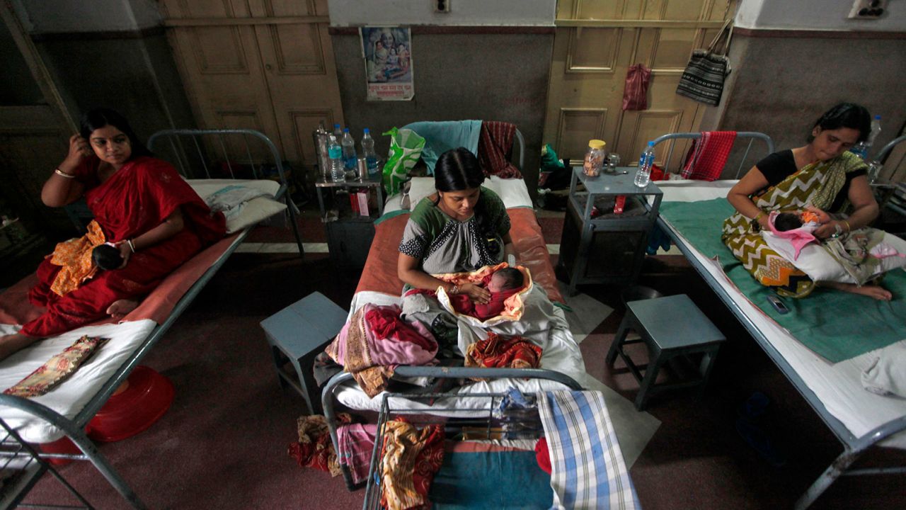 Mothers hold their newborn babies inside a maternity hospital during 