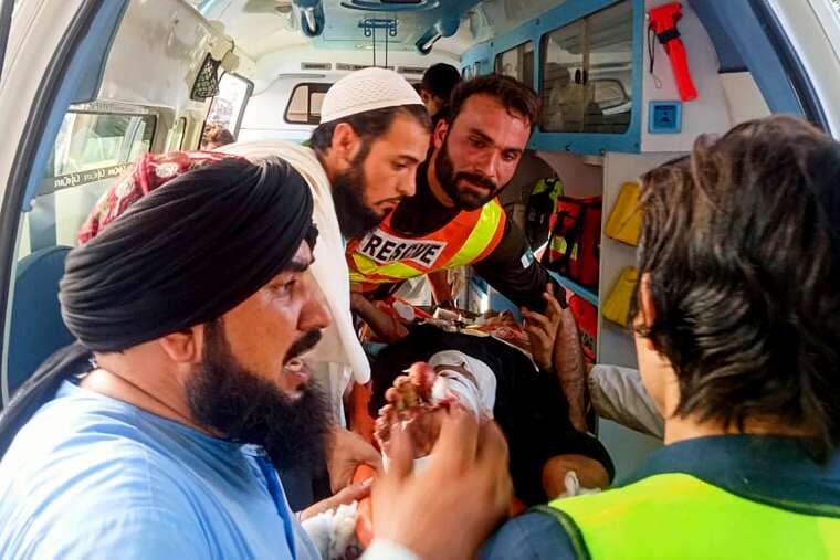 Rescue workers carry a wounded man after a bomb explosion in the Bajur district of Khyber Pakhtunkhwa, Pakistan, on July 30, 2023.