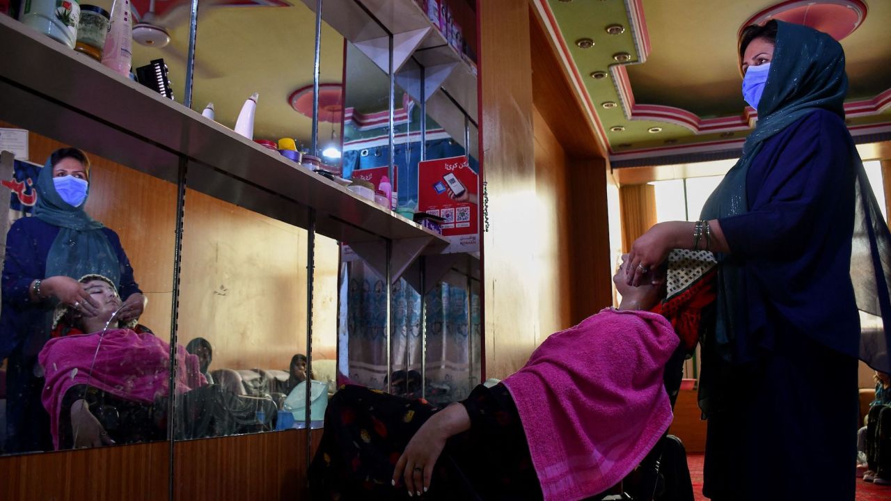 An Afghan beautician attends to a customer at a beauty salon in Mazar-i-Sharif on June 27, 2023.