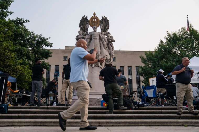 People wait around the George Gordon Meade Memorial outside of the E. Barrett Prettyman United States Courthouse