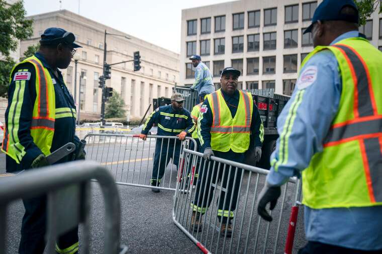 Workers install security fencing along 3rd St. in Washington, D.C.