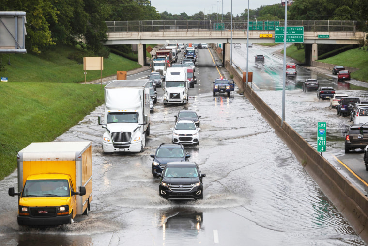 Dozens of vehicles drive through a flooded section of I-94 in Detroit on Friday, on Aug. 25, 2023.