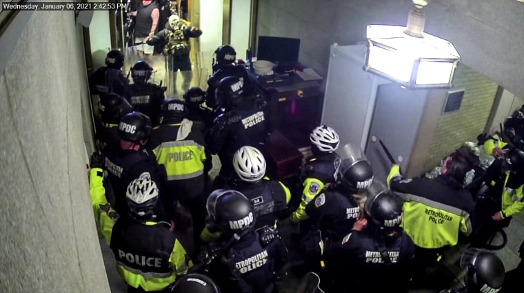 A man in a gas mask faces off with police on Jan. 6 2021 at the U.S. Capitol.