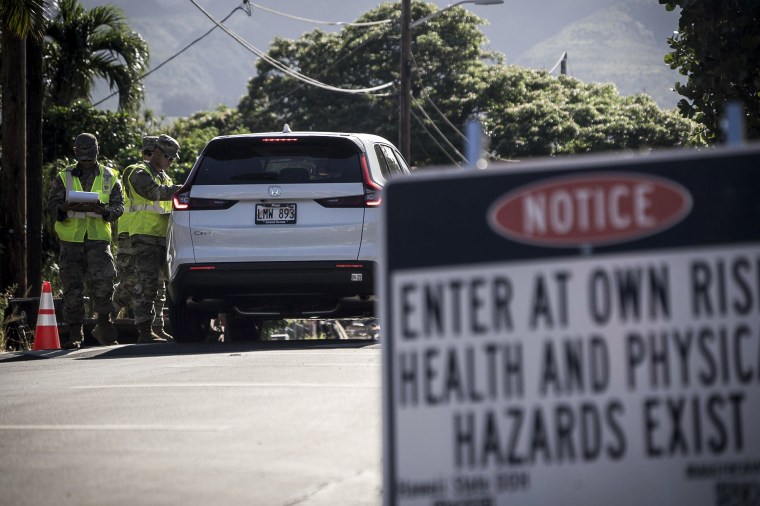 Image: The Hawaii National Guard checks on a car passing the checkpoint on Kaniau Street on Monday, Sept. 25, 2023, in Lahaina, Hawaii. Kaniau Street of Zone 1C is the first zone to be cleared for re-entry.