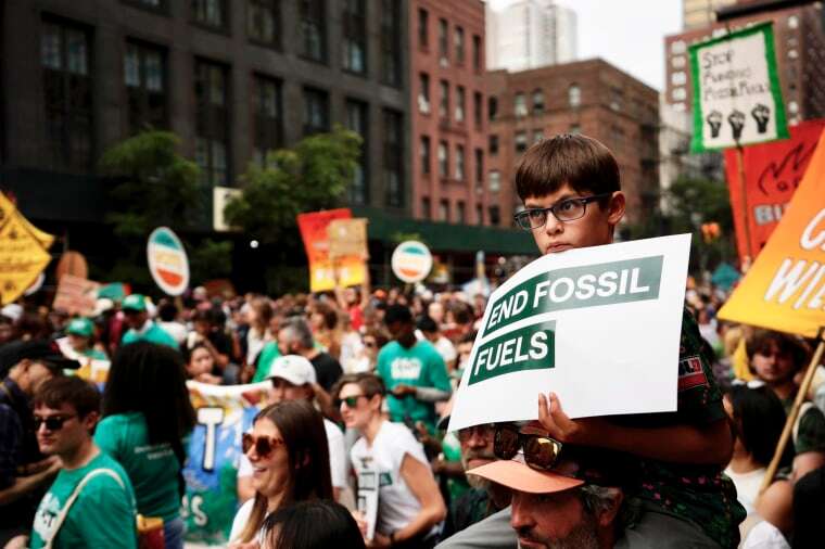 A boy listens to a speaker during a rally to end the use of fossil fuels in New York