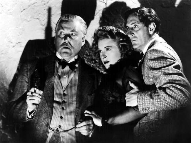 (From left to right) Nigel Bruce, Evelyn Ankers, and Basil Rathbone as seen in the 1942 film Sherlock Holmes and the Voice of Terror