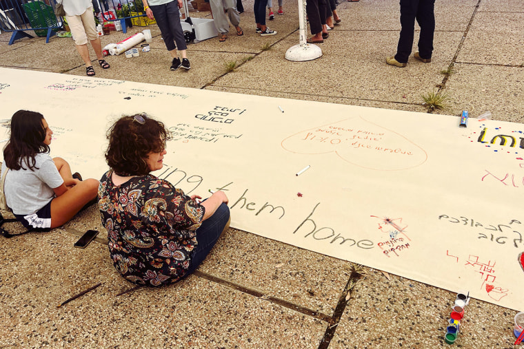 Visitors write messages on a banner at the museum.