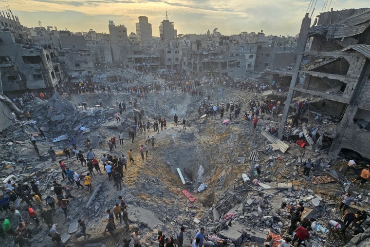 Palestinians search for casualties at the site of Israeli strikes on houses in Jabalia refugee camp