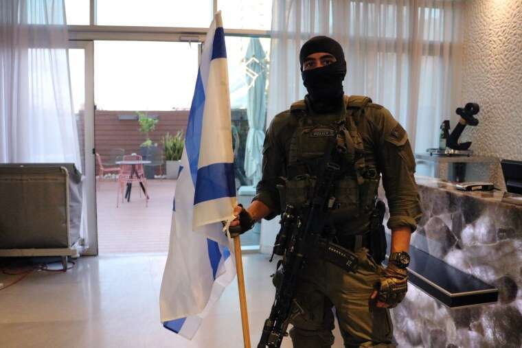 The officer, who identified himself as a "fighter in a special police unit," carried an Israeli flag.