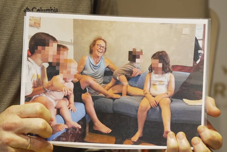 Nahar Neta holds a photo of Adrienne Neta with her grandchildren.