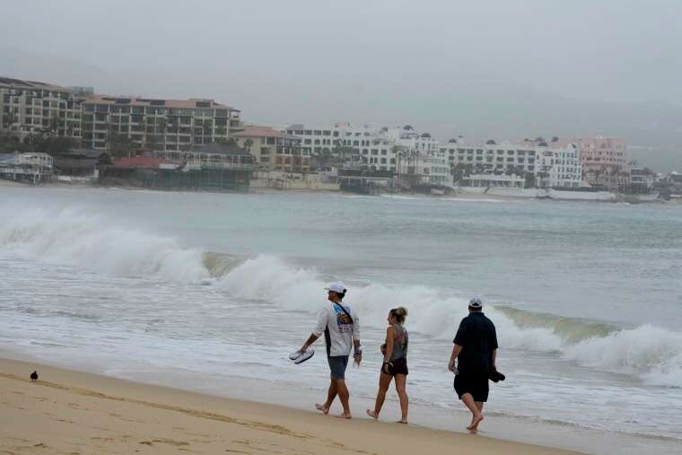 Tourists walk along the beach after Hurricane Norma's passage in Cabo San Lucas, Mexico, on Saturday.