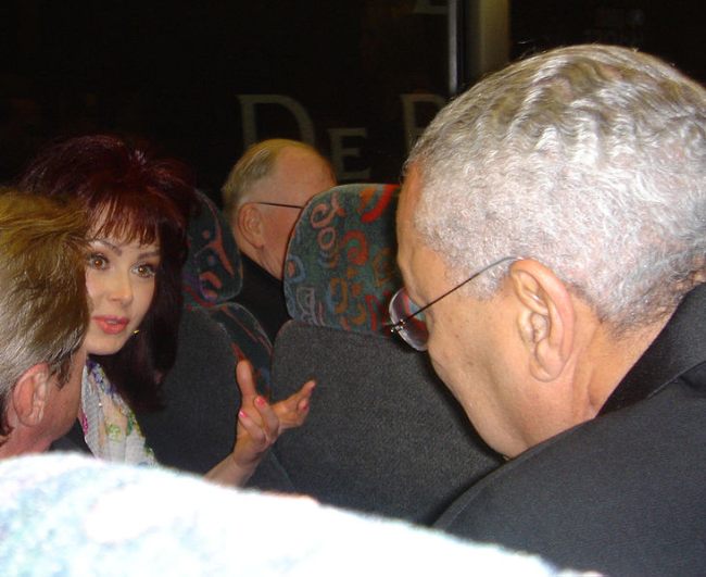 Naomi Judd seen leaning over to talk to General Colin Powell in 2005