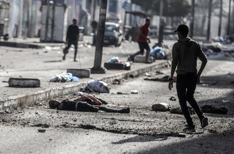 People walk among the dead on Nasir Street near Al-Shifa hospital in Gaza City.