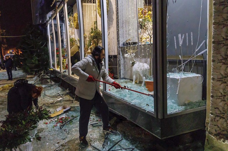 A man clears broken glass in a storefront after a Russian missile attack in Kharkiv, Ukraine, on Sunday in a photo provided by Kharkiv Regional Administration.