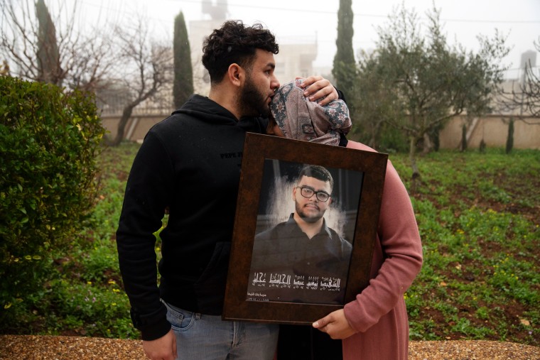 Amir Abdel Jabbar comforts his mother, Mona, their home village of Al-Mazra'a ash-Sharqiya in the West Bank on Jan. 23.
