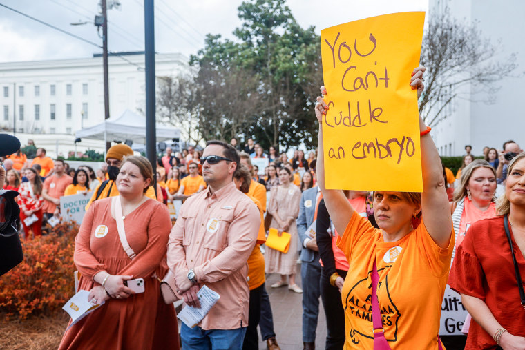 Carrie McNair holds a sign for IVF rights