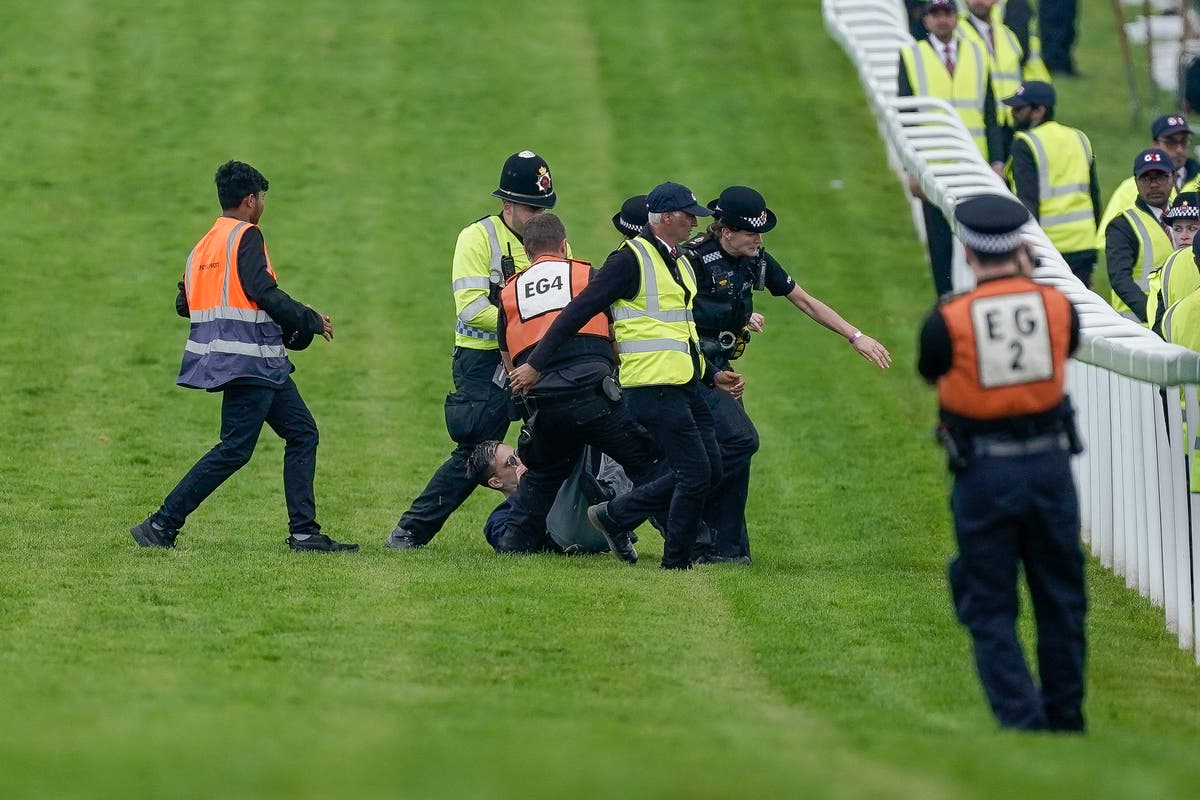 Protester tackled to ground after running onto race track at Epsom Derby