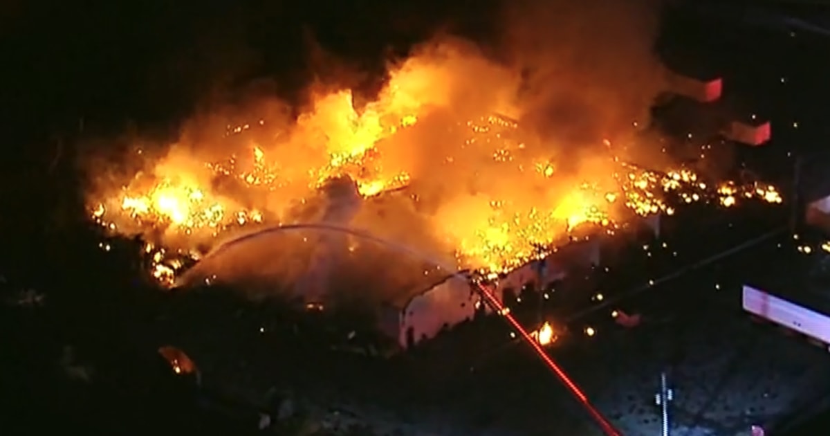 Huge fire ignites Michigan warehouse, raining debris 'as far as a mile away from the explosion,' police say