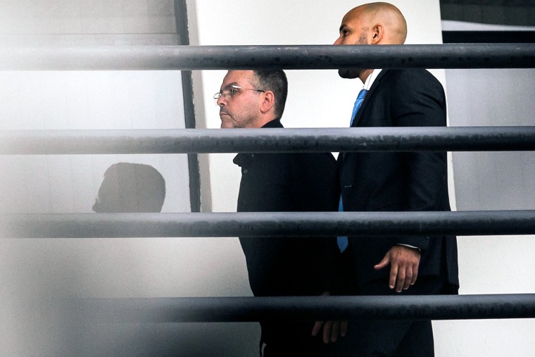 Rivaldo Barbosa is escorted by a federal police officer