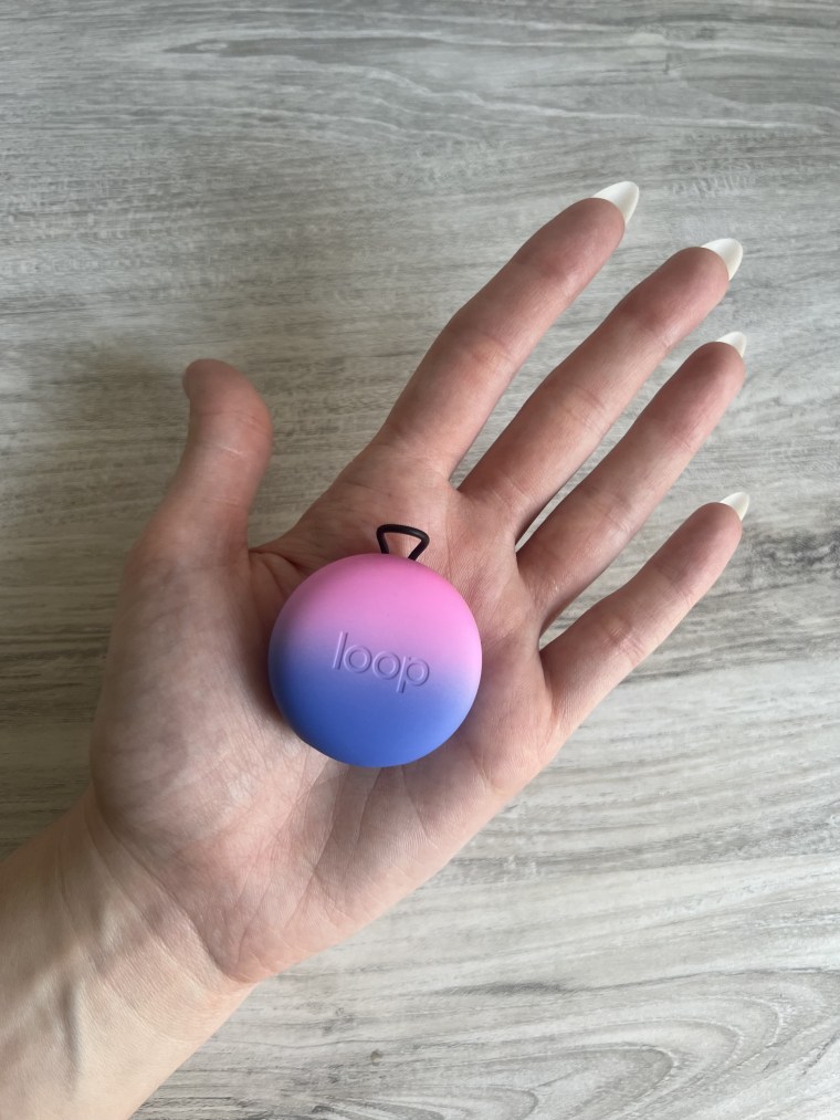 Picture of a hand holding a Loop Quiet earplugs case on the palm.